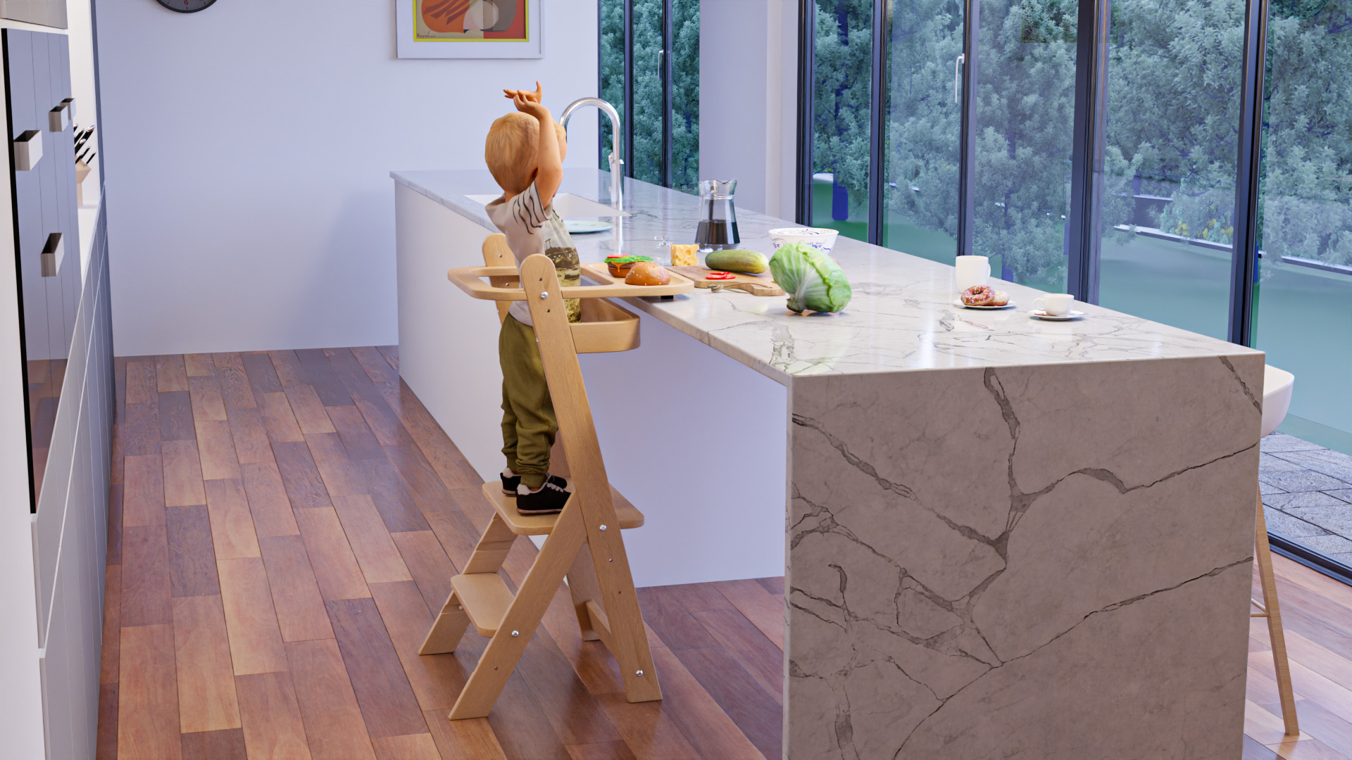 Child standing in a learning tower in a kitchen